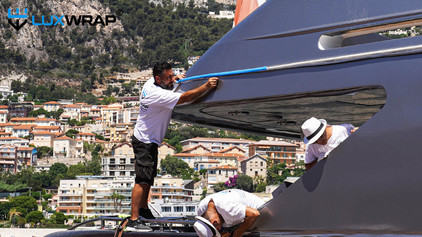 Wrapping large yacht superstructure silver, standing on bulwark.