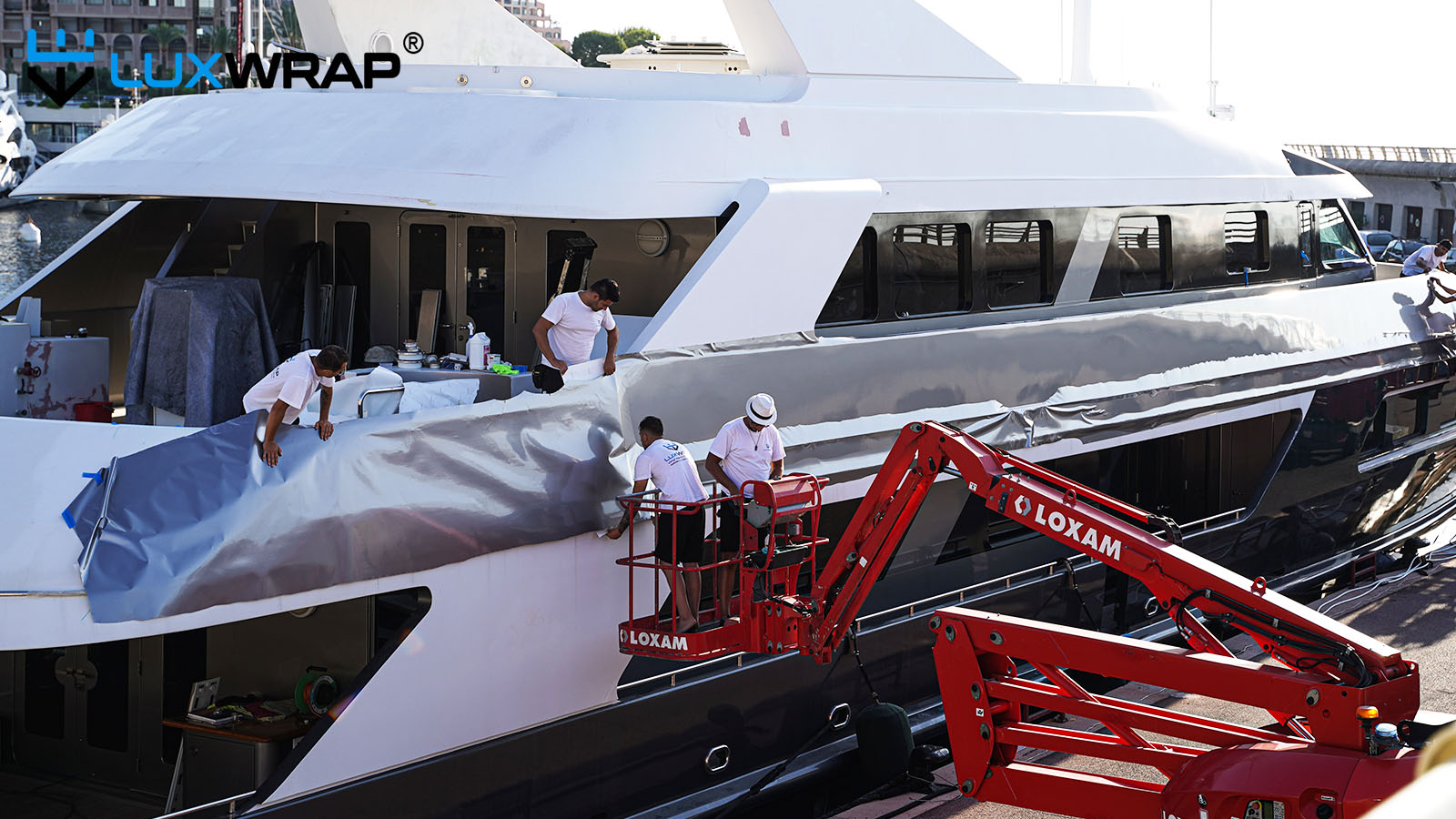 Wrapping large yacht superstructure from cherry pickers and step ladder