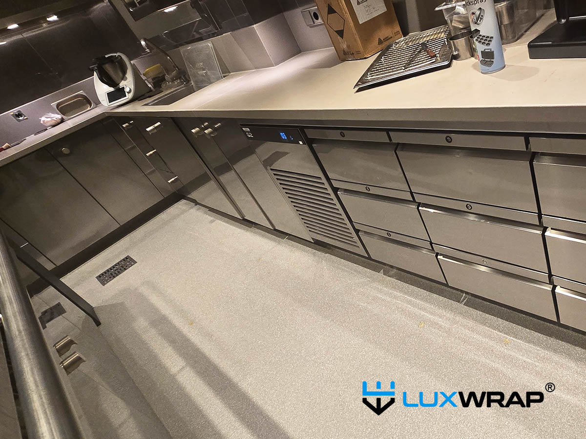 LuxWrap installation in progress — hob control area of an industrial galley cooker on a large superyacht, protected with surface protection film against scratches, abrasion, and daily operational wear.