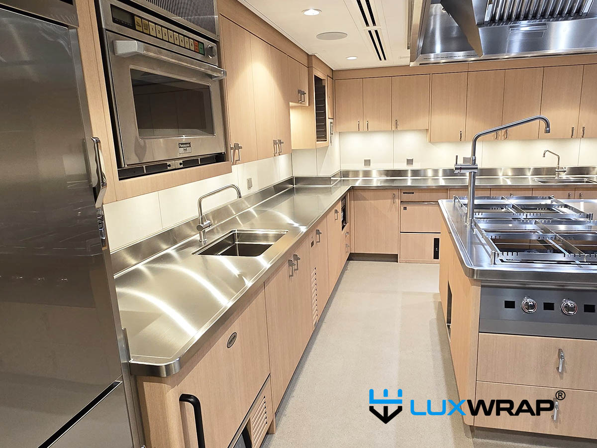 New-build yacht galley transformed from stainless to wood grain, with PPF elements