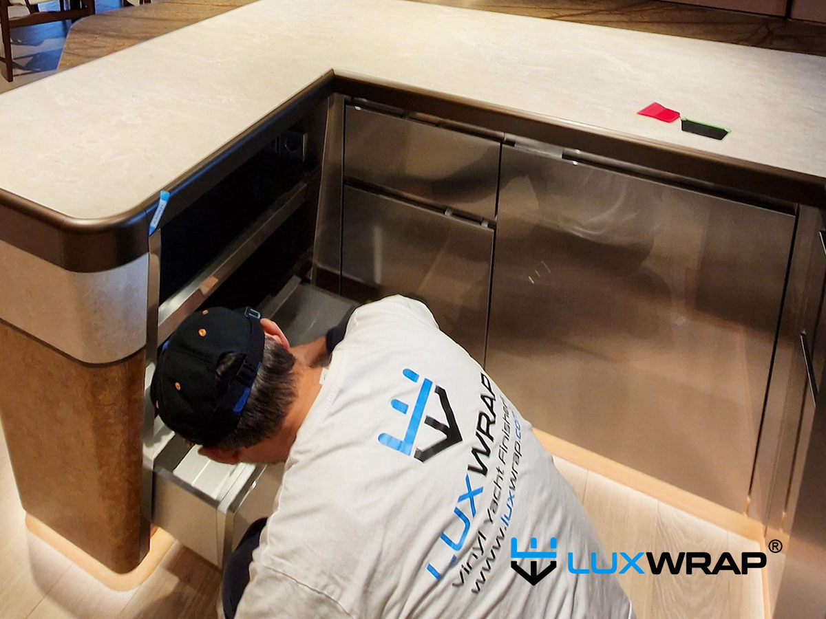 Installation of NinjaShield gloss paint protection film on a superyacht galley stainless steel surface