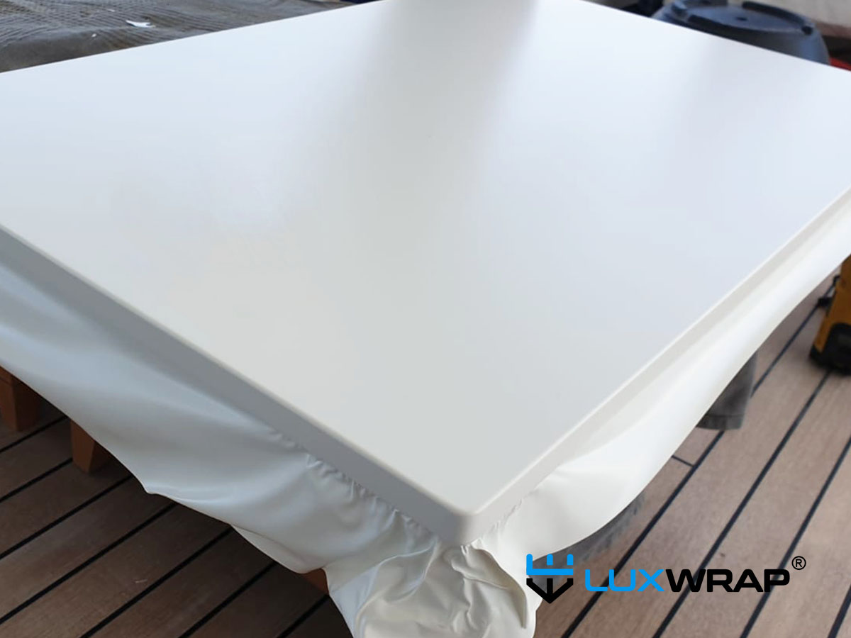 LuxWrap installer wrapping superyacht deckhead panels on-site — a clean, efficient process with no dust or solvents