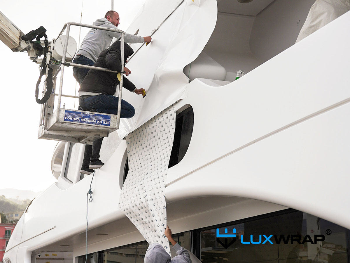 Advanced LuxWrap vinyl wrapping experts installing white vinyl on a large superyacht superstructure